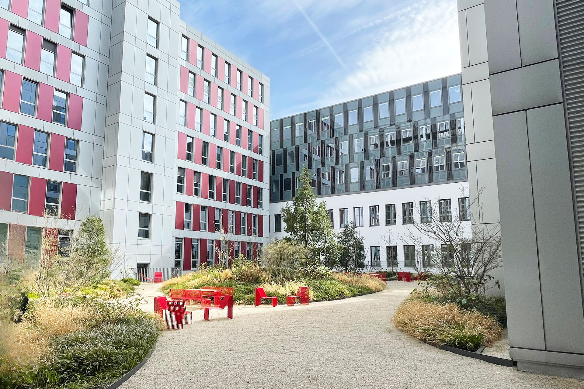 Innenhof moderner Bürogebäude mit Grünanlage, Sitzgelegenheiten und zeitgemäßer Architektur
